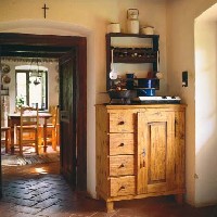 A tisztaszoba felé az eredetihez hasonló, tömörfa ajtókat helyeztek. Közvetlenül a bejárati ajtó mellett kapott helyet a házzal egyidõs, fölújított konyhakredenc, s a patinás fûszertartó. 