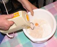 2. A lisztet kevertlba tesszk, hozzadjuk a tojst s a felfuttatott lesztt, s konyhai robotgppel sszekeverjk. Az olvasztott vajat a legvgn, kanalanknt adjuk hozz a tszthoz.